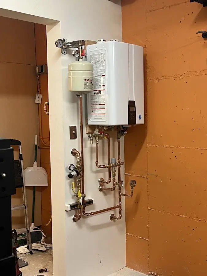 Plumbing technician inspecting water heater connections in Summerville